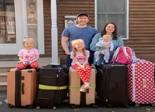 A family standing next to their luggage
Description automatically generated with low confidence